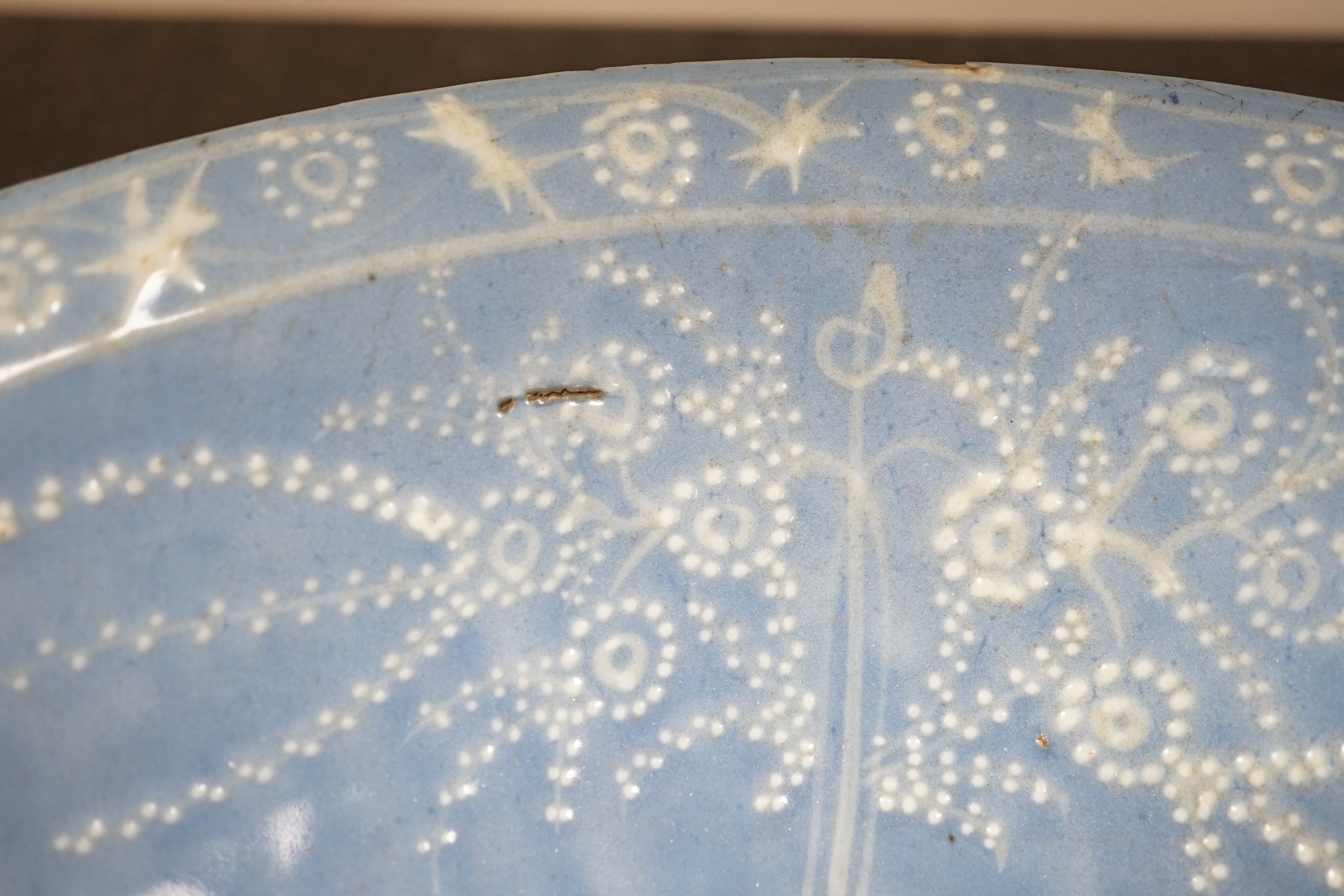 A Chinese Swatow slip-decorated blue glazed deep dish, Zhangzhou kilns, early 17th century, 38cm wide, crack to base